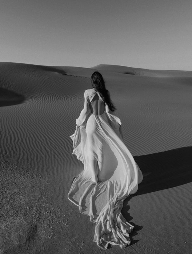 Fashion model in white dress in desert